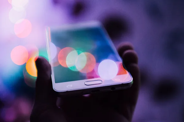 A smartphone held in one hand, screen lit